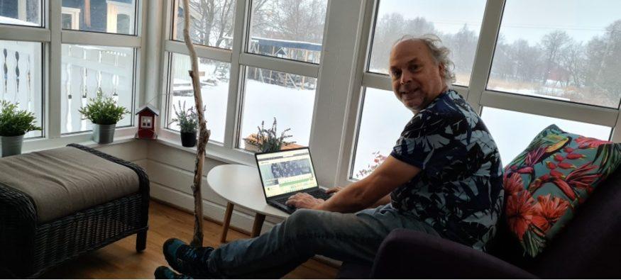 Louis werkt aan zijn stamboom op MyHeritage met uitzicht op de wintertuin